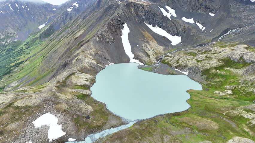 Scenic Drone Orbit over glacial Crystal Lake near Crow Pass in Alaska