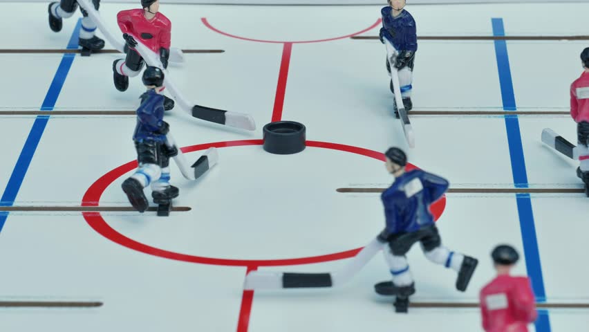 Table hockey players skating on ice during a match