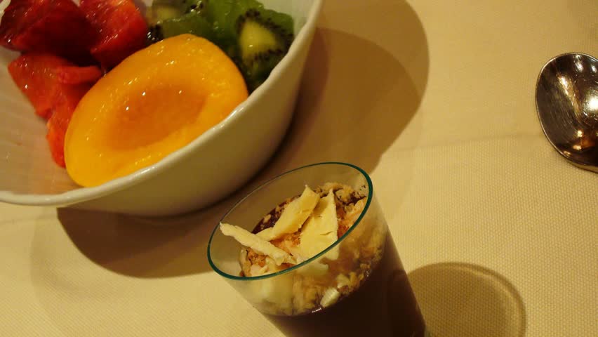 Dessert with fruit, kiwi, peach and watermelon with a delicious dark chocolate mousse with white chocolate shavings and nuts