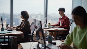 Young programmers coding computers sitting together at spacious coworking zone. Focused students learning software development practicing tasks. People typing keyboards actively at modern workspace - Powered by Shutterstock - Get 15% off with code: PIKWIZARD15