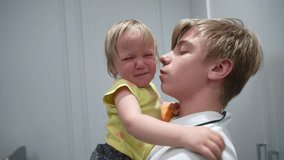 Young child gently comforts crying toddler sibling with tender, supportive embrace during emotional and heartfelt moment - Powered by Shutterstock - Get 15% off with code: PIKWIZARD15