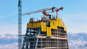 Urban development, skyscraper construction shot from above, aerial, surrounded by mountain views - Powered by Shutterstock - Get 15% off with code: PIKWIZARD15