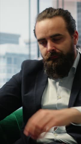 Vertical Video Male corporate leader buries his face in his hands due to frustration, pressure of a declining economy and battling the stress of a failing company. Business downfall and bankruptcy