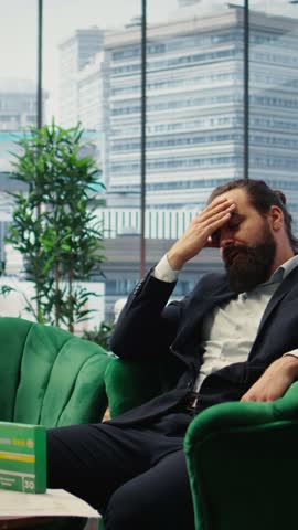 Vertical Video Concerned CEO taking an aspirin to ease the headache due to stress, feeling a discomfort and using painkillers. Tired uncomfortable boss deals with a migraine, burnout and tension
