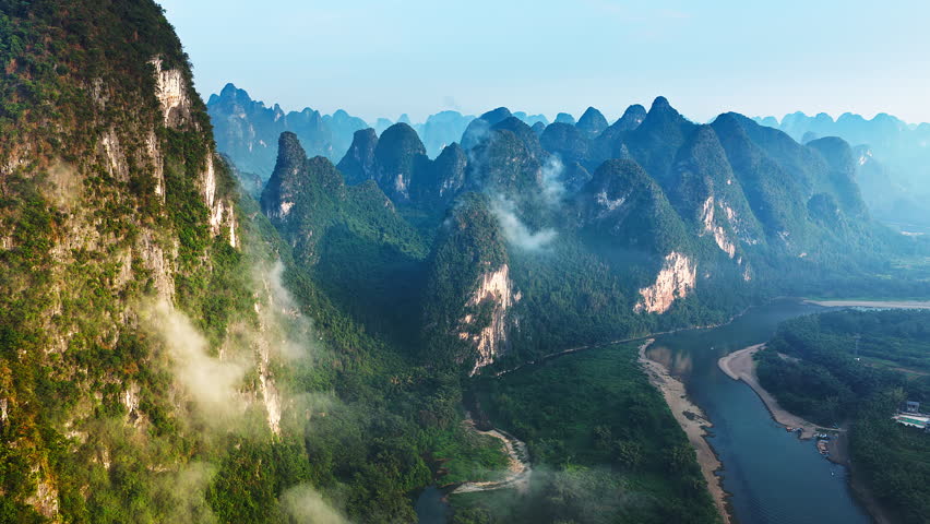 Aerial shot of the majestic karst mountain and river with green forest landscape in Guilin, China.