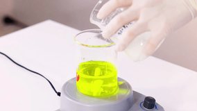 a chemistry experiment video showing the mixing of liquids in a beaker. this science lab demonstration features a chemical reaction and lab equipment. - Powered by Shutterstock - Get 15% off with code: PIKWIZARD15