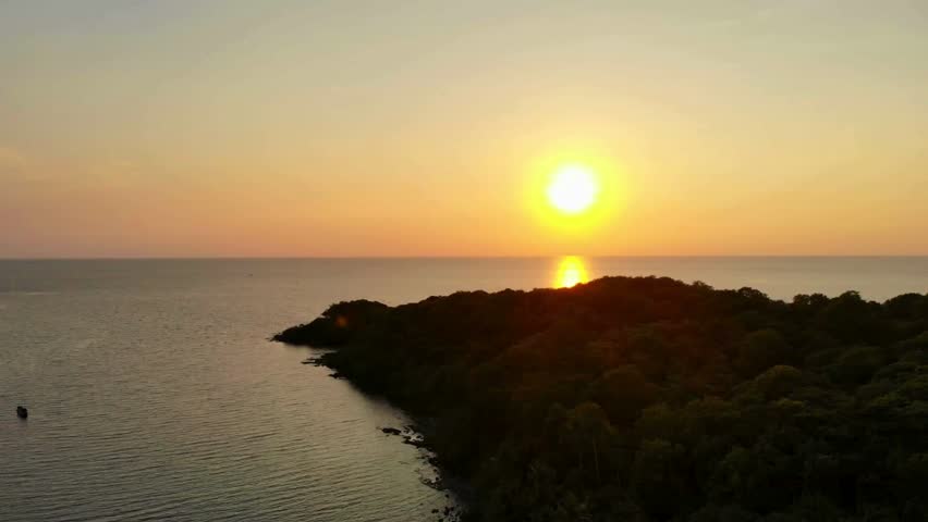 Golden sunset over a tropical island with the sun reflecting on the water