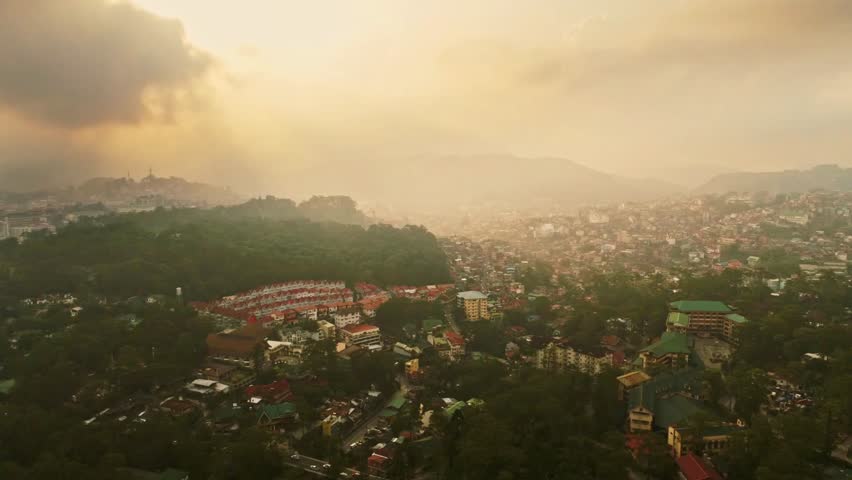 A hazy view of baguio city, philippines, nestled among lush green mountains