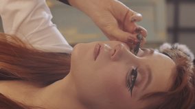 Makeup artist applying theatrical eyeliner on a beautiful model - Powered by Shutterstock - Get 15% off with code: PIKWIZARD15