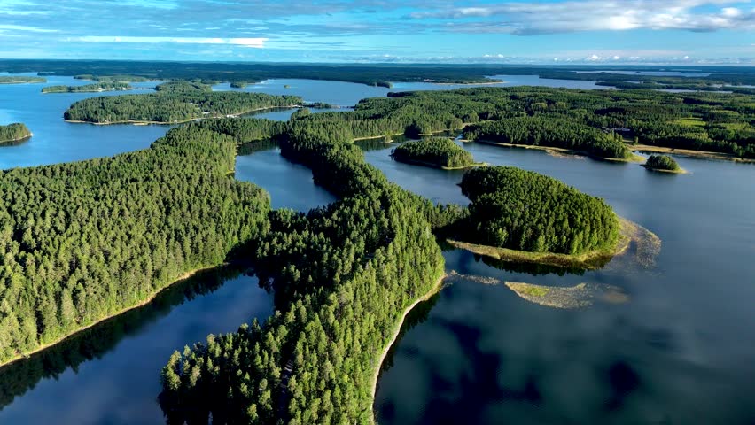 Explore the breathtaking landscapes of Punkaharju as the aerial perspective reveals the winding esker surrounded by tranquil lakes and dense forests. Punkaharju Nature Reserve Finland