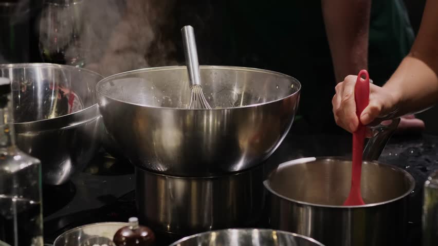 A group of people in a cooking class studio. Demonstration of culinary techniques. Professional kitchen accessories for the restaurant. Cooking on the stove.