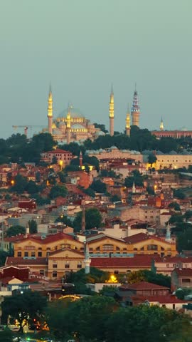 A vertical shot of the Suleymaniye Mosque and other historic landmarks towering over the rooftops of Istanbul