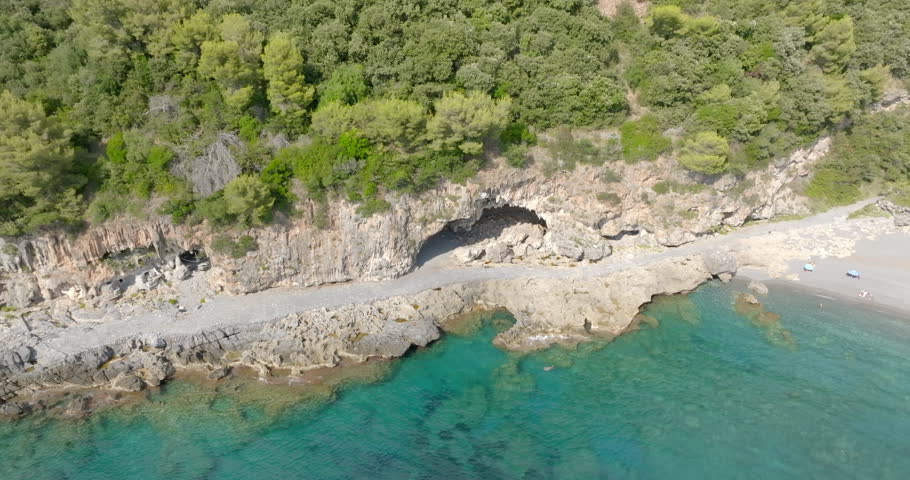 Aerial view of a cave carved into the rock near the Mediterranean coast.