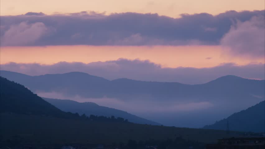 Mountain Sunset with Heavy Clouds and Rising Fog