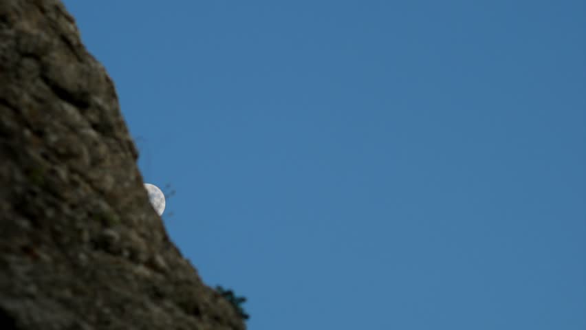 Waning Moon Rising Over Mountain in Blue Night Sky
