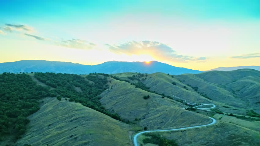 Aerial scenery, beautiful mountainscape, hills with curvy road, green forest, skyline