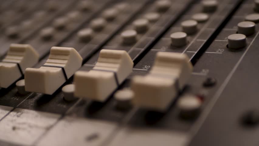 professional audio mixing console with multiple sliders and buttons, highlighting the intricate details of sound engineering equipment used in music production, live performances, or broadcasting