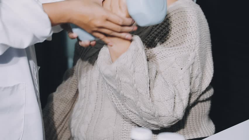 Senior woman exercises arm with hand weight at doctor