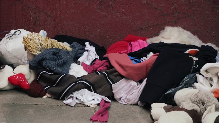 Clothes for recycled. Pile of old, used clothing. The problem of textile waste. Concept of disposal, recycling, donation old clothes. High quality 4k footage