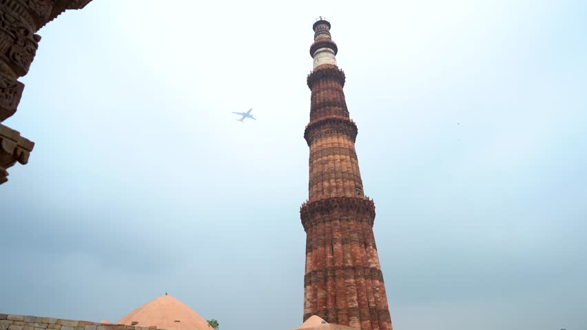 Airplane Passing Over Qutub Minar in Delhi, India