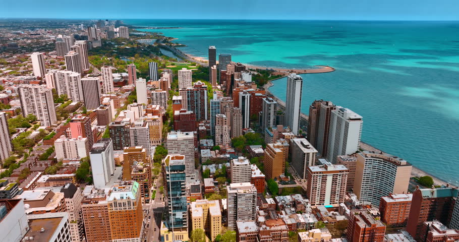 Sunny scenery of Chicago at the shore of Lake Michigan. Drone footage over the downtown revealing view on the vast city and turquoise waterscape.