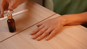 A woman is caring for her hands by applying a special serum to strengthen her nails. Hand care and manicure. Nail and fingertip skin care. Close-up. - Powered by Shutterstock - Get 15% off with code: PIKWIZARD15