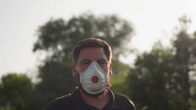 close up of man spraying crops with backpack sprayer wearing mask and glove under golden sunlight creating lens flare while performing outdoor fumigation and pest control on leafy plants - Powered by Shutterstock - Get 15% off with code: PIKWIZARD15