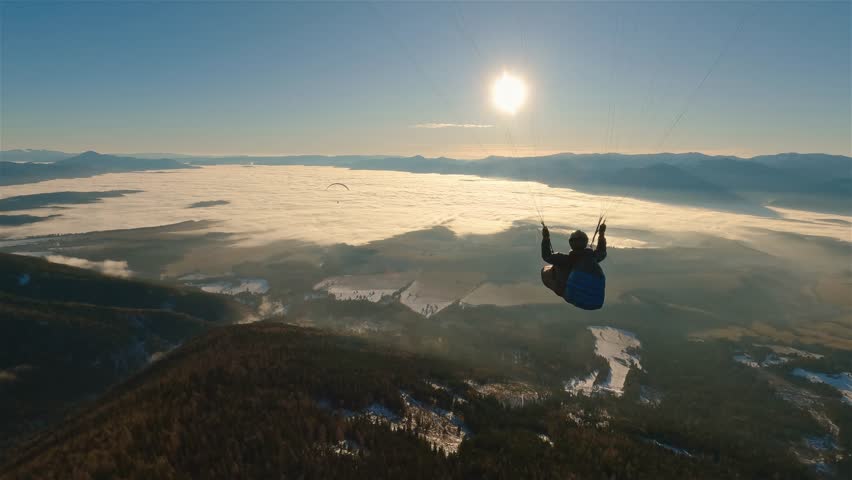 Paragliding Above Misty Mountains at Sunrise, Peaceful Flying Freedom