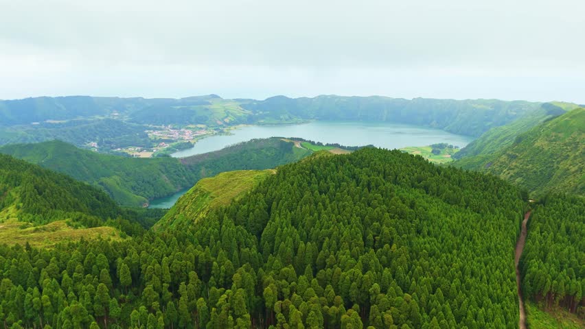 Sete Cidades Caldera on Cloudy Day. Blue Lake and Santiago Lake. Azores, Sao Miguel Island. Portugal. Aerial View. Drone Moves Forward and Upwards. Reveal Shot