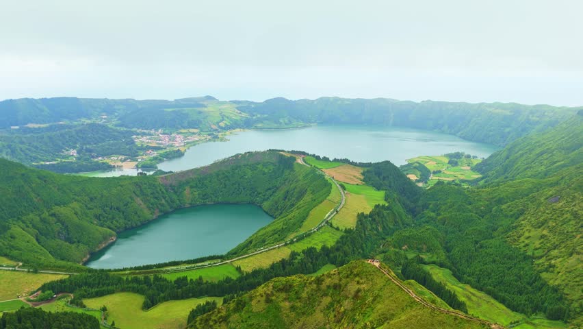 Sete Cidades Caldera on Cloudy Day. Blue Lake and Santiago Lake. Azores, Sao Miguel Island. Portugal. Aerial View. Drone Moves Forward and Upwards. Reveal Shot