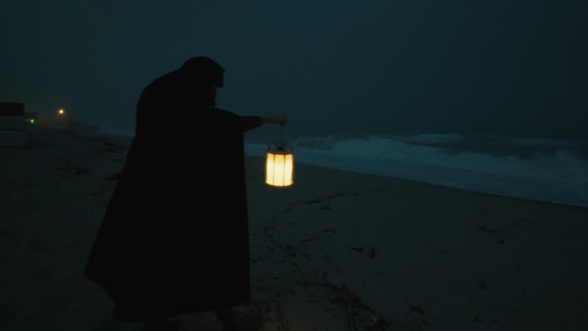 Halloween Night A Man With A Cloak And A Lantern Mysteriously Wanders The Beach