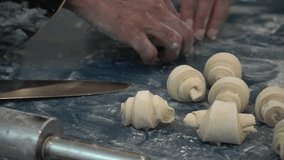Close-up of a baker's hands rolling and shaping croissant dough on a floured countertop. - Powered by Shutterstock - Get 15% off with code: PIKWIZARD15