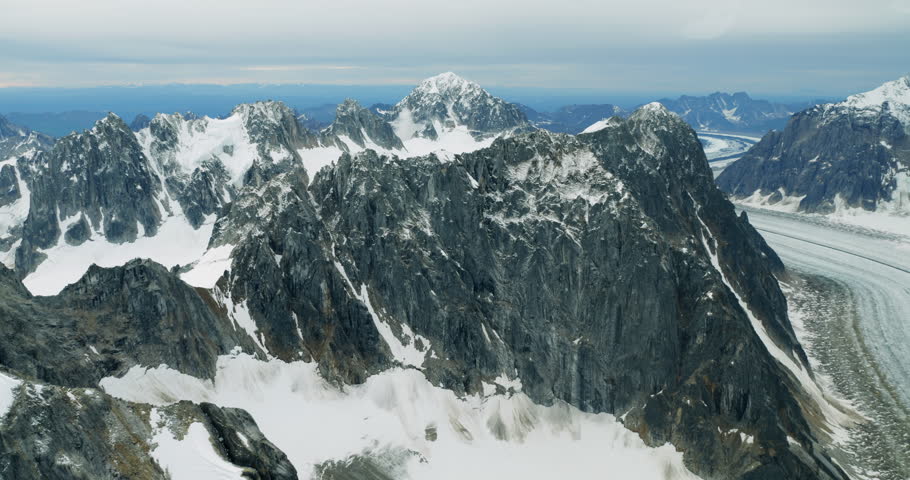 Aerial shot of snowy mountains in Alaska. Flying small plane along Denali National Park 