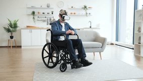 Older man in wheelchair experiencing virtual reality using VR headset, engaging in physical gesture-based interaction in a modern, bright indoor setting. - Powered by Shutterstock - Get 15% off with code: PIKWIZARD15