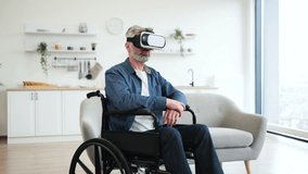 Senior man wearing VR headset explores virtual interface while seated in wheelchair indoors. Concept of accessibility, modern technology, and gaming for older adults. - Powered by Shutterstock - Get 15% off with code: PIKWIZARD15
