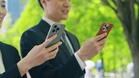 A male business person using a smartphone in a city with fresh greenery - Powered by Shutterstock - Get 15% off with code: PIKWIZARD15