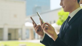 A male business person using a smartphone in a city with fresh greenery - Powered by Shutterstock - Get 15% off with code: PIKWIZARD15