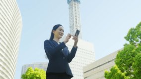 Female business person using a smartphone in the city - Powered by Shutterstock - Get 15% off with code: PIKWIZARD15