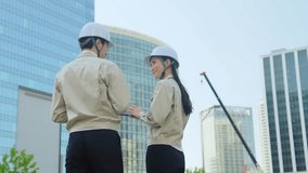 A group of male and female engineers having a meeting while looking at a tablet at a construction site - Powered by Shutterstock - Get 15% off with code: PIKWIZARD15