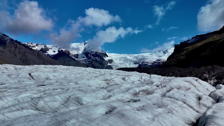 Explore the breathtaking Svinafellsjokull Glacier in Iceland, where intricate ice patterns and rugged terrain create a striking landscape under a moody sky, revealing natures wonders.