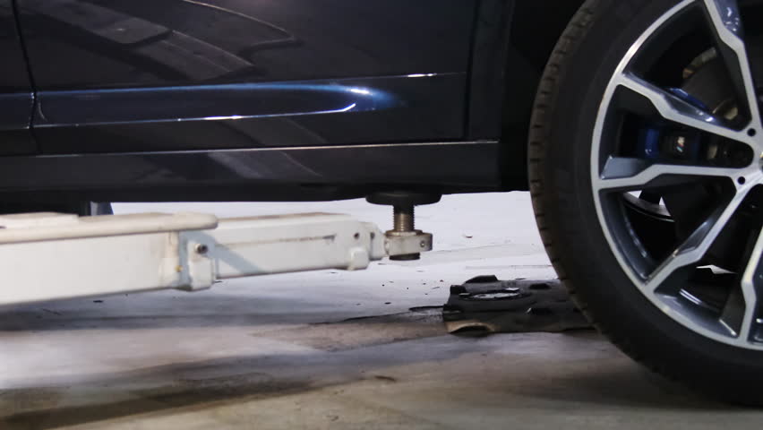 Special equipment lowers car to floor after work process. Lift allows to move vehicle in service station hall improving visibility of details