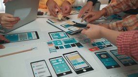 A diverse team gathers around a table to collaborate on digital prototypes and designs. This engaging workspace highlights creativity and teamwork in action. SACTR - Powered by Shutterstock - Get 15% off with code: PIKWIZARD15