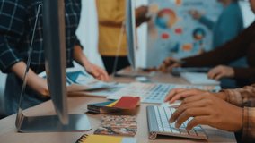 Creative professionals collaborate in a modern office setting, utilizing color swatches and digital tools to brainstorm and develop innovative design solutions. SACTR - Powered by Shutterstock - Get 15% off with code: PIKWIZARD15