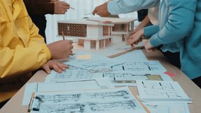 A dynamic scene of architects and designers collaborating in a creative workspace, drafting plans and building models while surrounded by blueprints and materials. SACTR - Powered by Shutterstock - Get 15% off with code: PIKWIZARD15