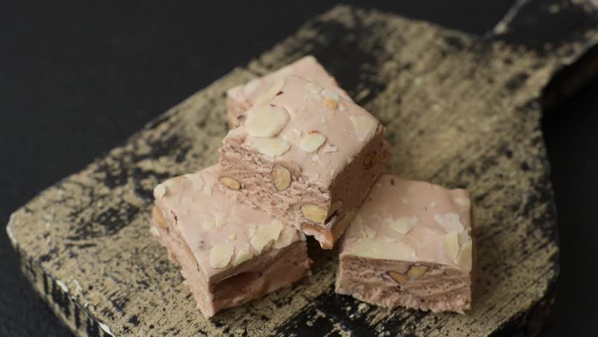 Nougat or white caramel with hazelnuts and pistachios and citrus pieces. White nougat with nuts, sweets for the festive table