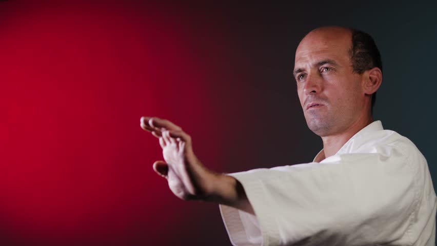 A young male athlete practices punching on a multi-colored background with flashing red and green lights