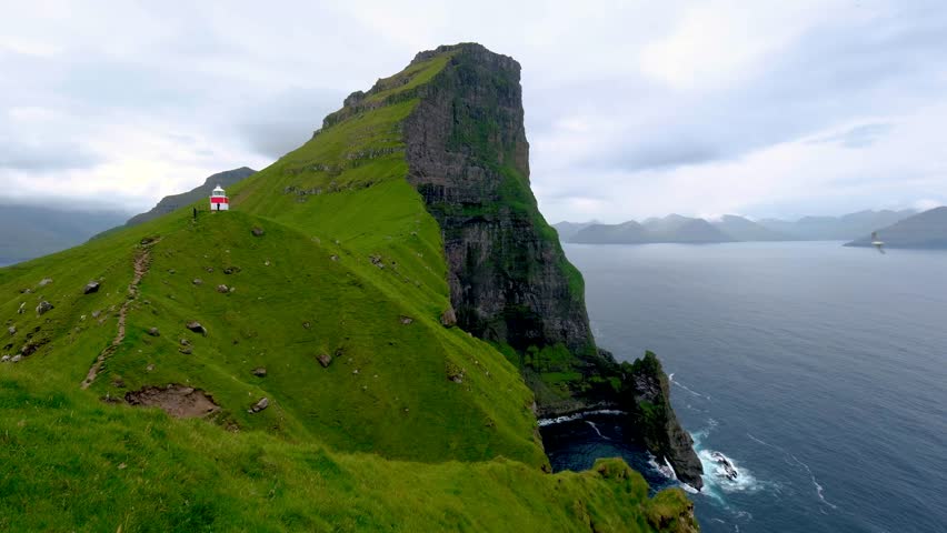 Explore the dramatic cliffs and lush greenery of Kalsoy Island in the Faroe Islands.
