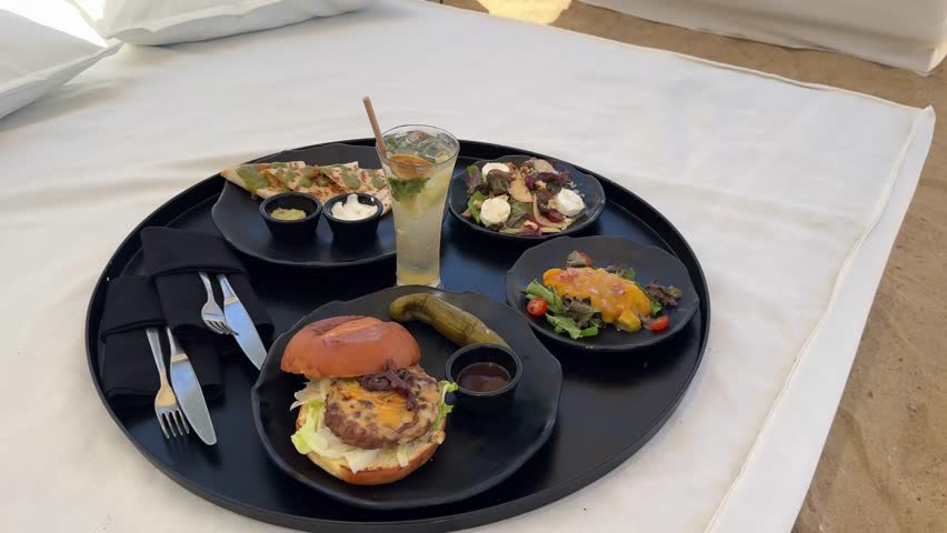 A luxurious poolside lunch at the Serry Beach Resort. Indulge in gourmet burgers, vibrant salads, and a frosty cocktail amidst serene sun loungers – the epitome of a perfect vacation escape.