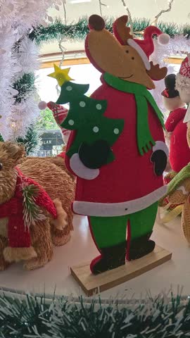 Panning left showing the contents of a shelf where Christmas theme ornament with reindeer and bear figures in a festive setting showing holidays shopping
