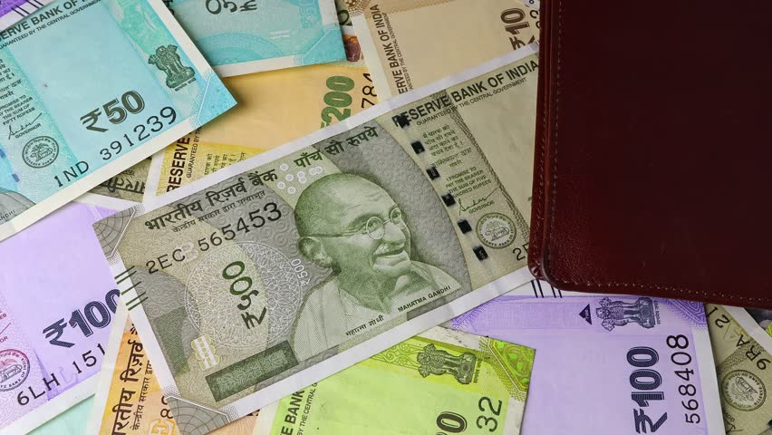 Macro shot of wallet and indian rupee (INR) banknotes. Concept of saving money for retirement, cash settlement, financial goals, success, literacy and income planning in India.